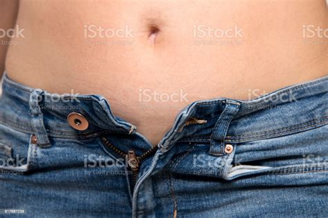 Woman With Belly Fat Unable To Close Jeans Button Stock Photo