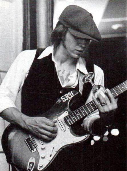 A Black And White Photo Of A Man Playing An Electric Guitar