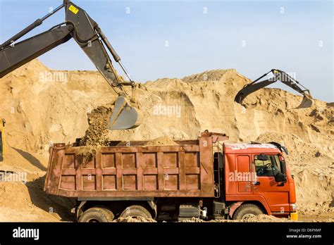 Excavator Loading Dumper Truck At Construction Site Stock Photo Alamy