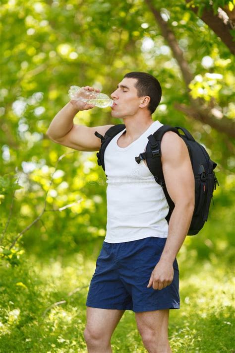 Active Man Drinking Water From A Bottle Outdoor Young Muscular Male