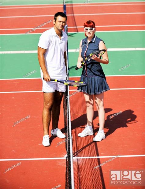 Happy Young Couple Play Tennis Game Outdoor Man And Woman Stock Photo