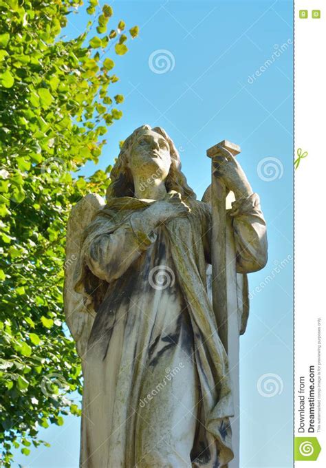 Adorned with a butterfly resting on her arm and a lovely flower crown upon her head, this collectible statue can be. Statue of a praying angel stock photo. Image of cross ...