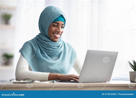 Portrait Of Black Islamic Woman In Hijab Working On Laptop In Office
