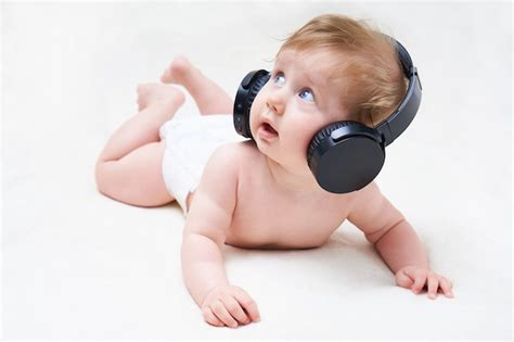 Lindo Bebé Está Acostado Boca Abajo Con Auriculares Y Escuchando Música