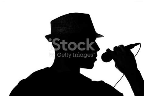 A Male Singer In A Hat Is Silhouetted On White Holding A Microphone