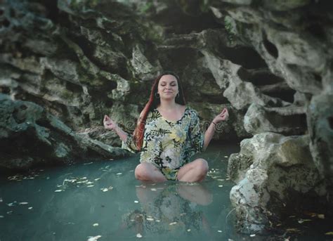 Woman Meditation In Lake Surrounded By Rocks Lotus Position Stock