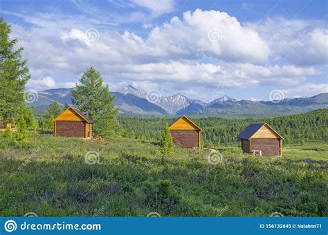House For Rest In Taiga Against The Background Of The High Mountains Of