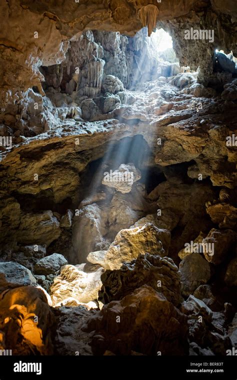 A Shaft Of Light Shining Into A Cave On An Island In Halong Bay