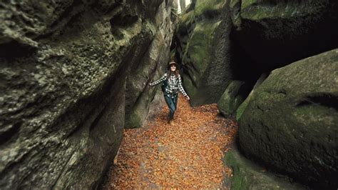 Woman exploring a cave in the forest - Free Stock Video