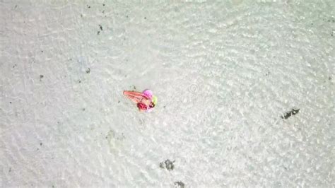 aerial view of people in summer holiday vacation with beautiful girl on coloured trendy lilo