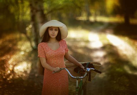 Фото Девушка в шляпе и розовом платье с велосипедом
