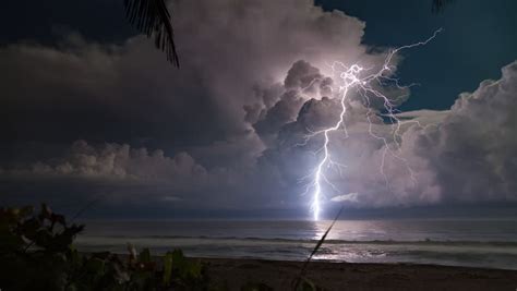Cinematic Storm Clouds With Lightning Strikes Reflecting In Ocean