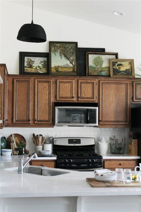 I balance all my decor on top of little boxes that are approximately the same height as the top of the cabinet to where the crown moulding meets. How to Decorate Above the Cabinets