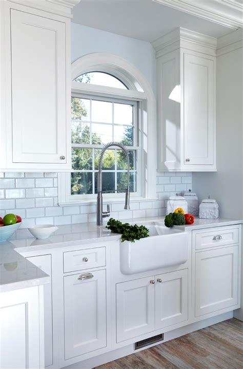 The blue and green backsplash enhances the room's coastal charm. White Kitchen Design Ideas | White Kitchen Cabinets