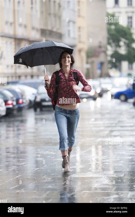 Photo Of Woman In Red Dress With Umbrella Walking In The Rain On A City