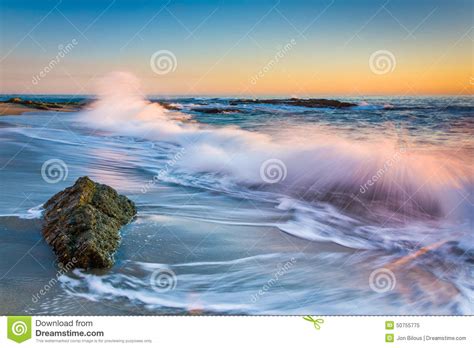 Waves crashing on california beach. Waves Crashing On Rocks At Sunset, At Victoria Beach Stock ...