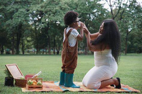 Madre Joven Africana Sosteniendo Un Vaso De Leche Para Que Su Hijo Tome