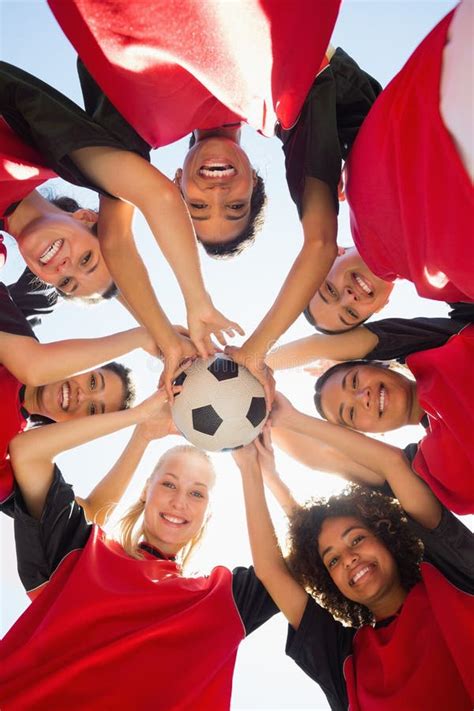 Soccer Team With Ball Forming Huddle Against Sky Stock Photo Image