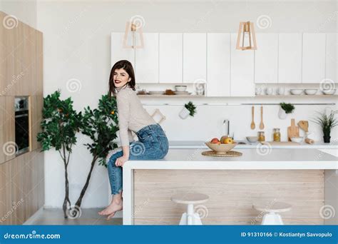 Girl Sitting On The Kitchen Table Bright White Kitchen Happy Smiling