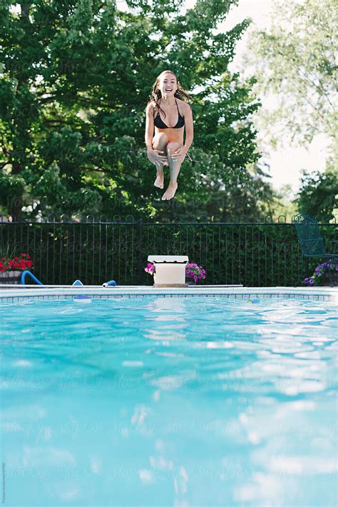 Girl Jumping Into The Swimming Pool By Stocksy Contributor Preappy Stocksy