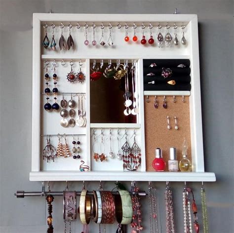A Wall Mounted Jewelry Organizer With Lots Of Earrings