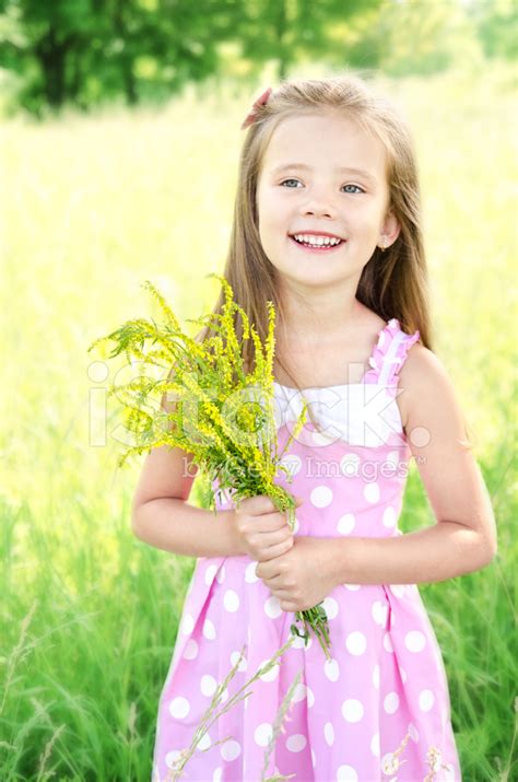 Portrait Of Adorable Smiling Little Girl With Flowers Stock Photo