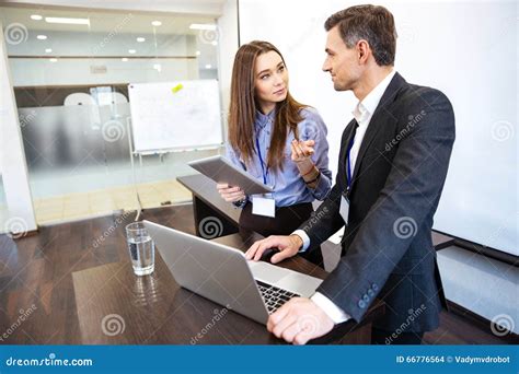 Two Business People Working Together Uing Laptop And Tablet Stock Photo