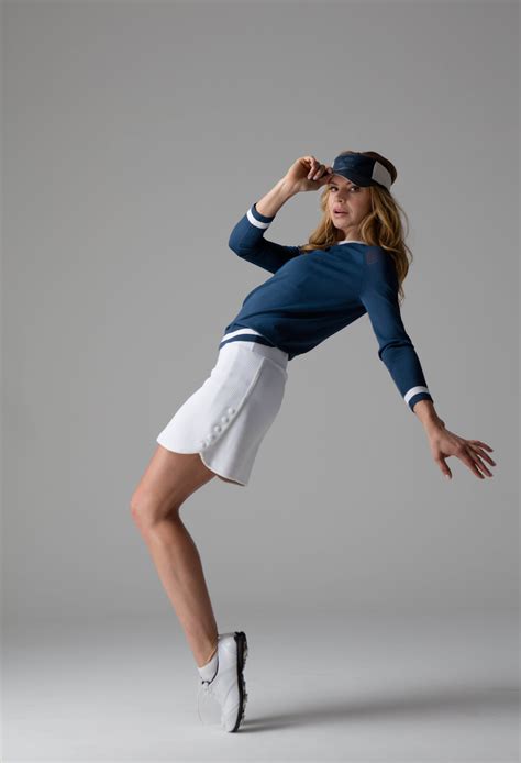 a woman in tennis clothes is posing for the camera
