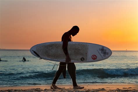 Man Carrying White Surfboard on Beach · Free Stock Photo