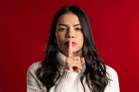 Woman With Long Hair Holding Finger On Her Lips Over Red Background Gesture Of Shhh Secret