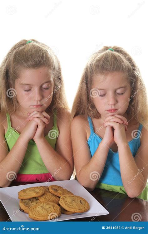 Two Girls Praying Over Cookies Stock Photography Image 3641052