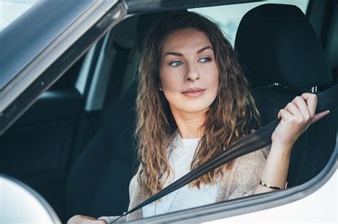 genç kadın bir arabada oturarak onun emniyet kemeri stok fotoğraf koyarak stok fotoğraflar
