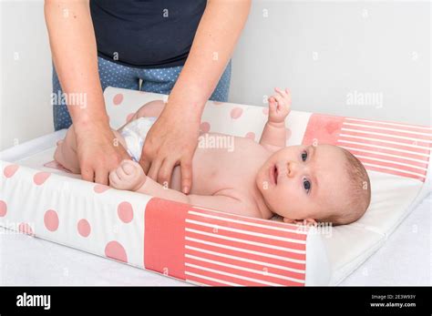 Mother Is Changing Diaper To Her Little Baby In Child Room At Home
