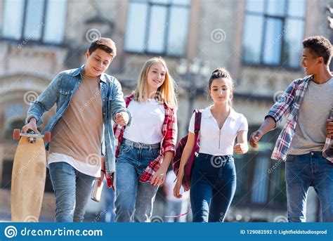 Group Of Happy Multiethnic Teenagers With Backpacks Having Walk