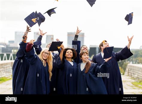 Happy Graduates Or Students Throwing Mortar Boards Stock Photo Alamy