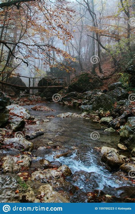 Beautiful Wooden Bridge Over A Mountain River In Fall