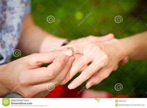 A Hand Of A Man Putting A Ring On A Girls Finger Stock