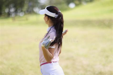 Professional Woman Golf Player Pose With Golf Club On Field Stock Photo