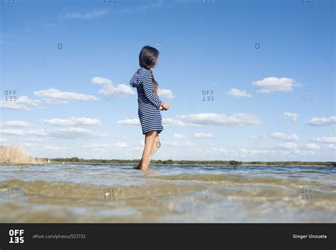 Girl In Striped Dress Wading In Water Stock Photo Offset