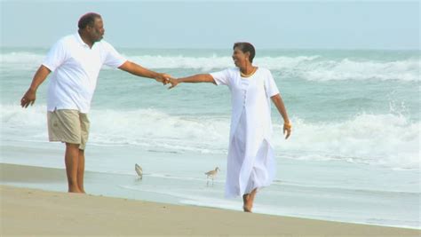Carefree Senior Couple Romantically Dancing Together On A Beach At