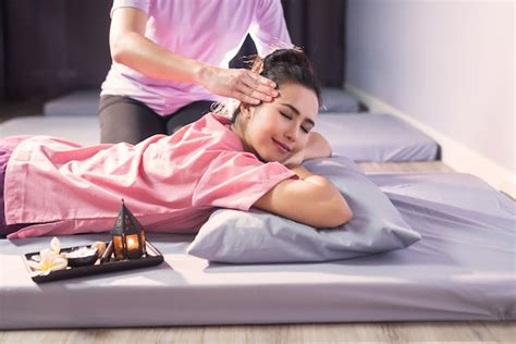 Premium Photo Thai Head Massage On Bed With Candle And Plumeria Flower In Spa Salon
