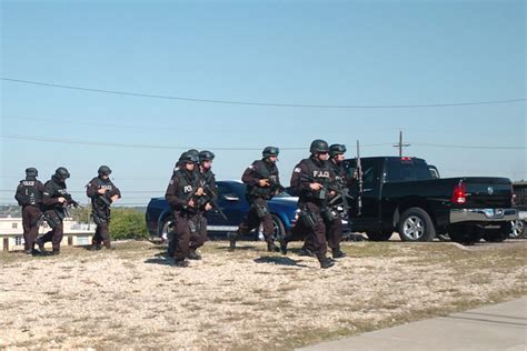 Swat Team Members Approach A Building With A Gunman Inside Texas
