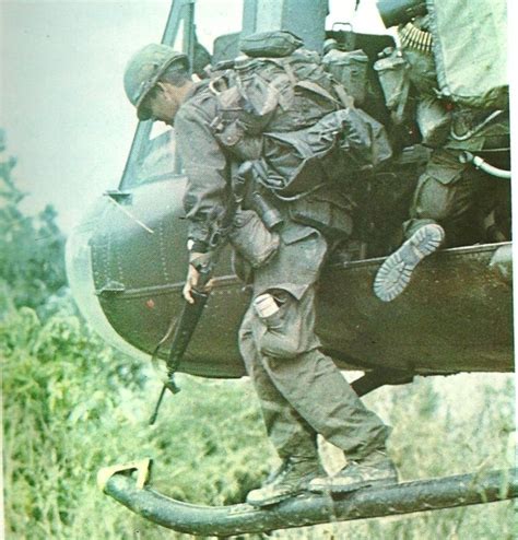 A Man In Fatigues Climbing Out Of A Helicopter
