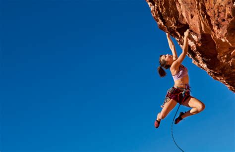 Female Climber Clinging To A Cliff Stock Photo Download Image Now