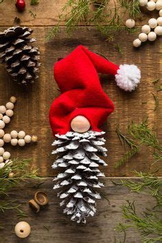 An Elf Is Sitting On Top Of Pine Cones And Other Christmas Decorations