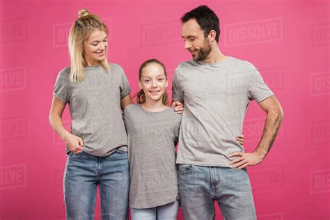 Happy Parents Hugging With Daughter Isolated On Pink Stock Photo