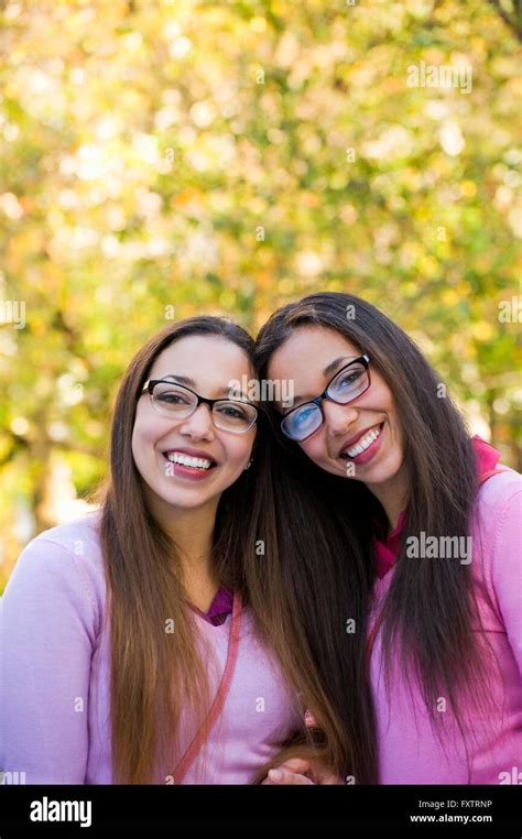 Twin Sisters Smiling Wide In Park Stock Photo Alamy
