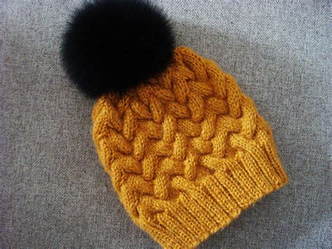 It`s definitely a unisex pattern so why not make one for every family member in their favorite colors. Sandy Winter Cable Hat | AllFreeKnitting.com