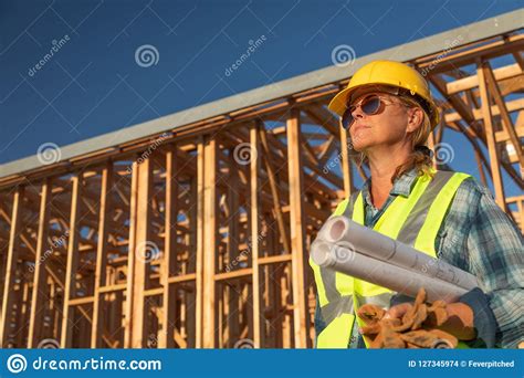 Female Construction Worker Holds Blueprints At Construciton Site Stock