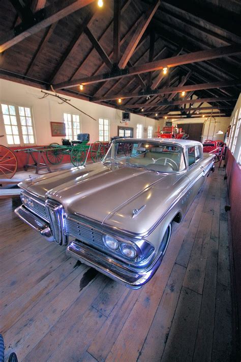 an old silver car is parked in a building with wooden floors and